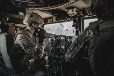 Military personnel operating tactical communications equipment, representing RTX defense technology, RTX raised 2026 outlook, Collins Aerospace TruNet systems and growing military demand